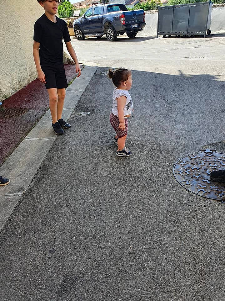 Tiana participe au concours pour gagner de l'argent avec cette photo : ankle, asphalt, auto_part, automotive_exterior, automotive_tail_brake_light, bermuda_shorts, clothing, family_car, human_body, leg, person, road_surface, shadow, shorts, sport_utility_vehicle, t_shirt, tar, truck, vehicle_door