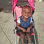 toddler, child, stroller, pink, rainbow, denim, dress, smile, happy, outdoor, sidewalk, shoes, white_socks, sunlight, concrete, baby, seatbelt, person, cute, daytime