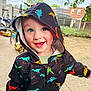 toddler, child, hoodie, dinosaur_pattern, smiling, outdoor, playground, bicycle, ball, joyful, happy, face, clothing, hood, sky, tree, fence, ground, daylight, person