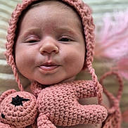 Maïlya a rejoint le concours — aidez-le/la à gagner de superbes lots ! baby, infant, face, crocheted_hat, crocheted_toy, pink, soft_texture, close_up, cute, child, portrait, handmade, knitted, adorable, smiling, indoors, young_child, headwear, plush_toy, newborn