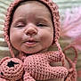 baby, infant, face, crocheted_hat, crocheted_toy, pink, soft_texture, close_up, cute, child, portrait, handmade, knitted, adorable, smiling, indoors, young_child, headwear, plush_toy, newborn