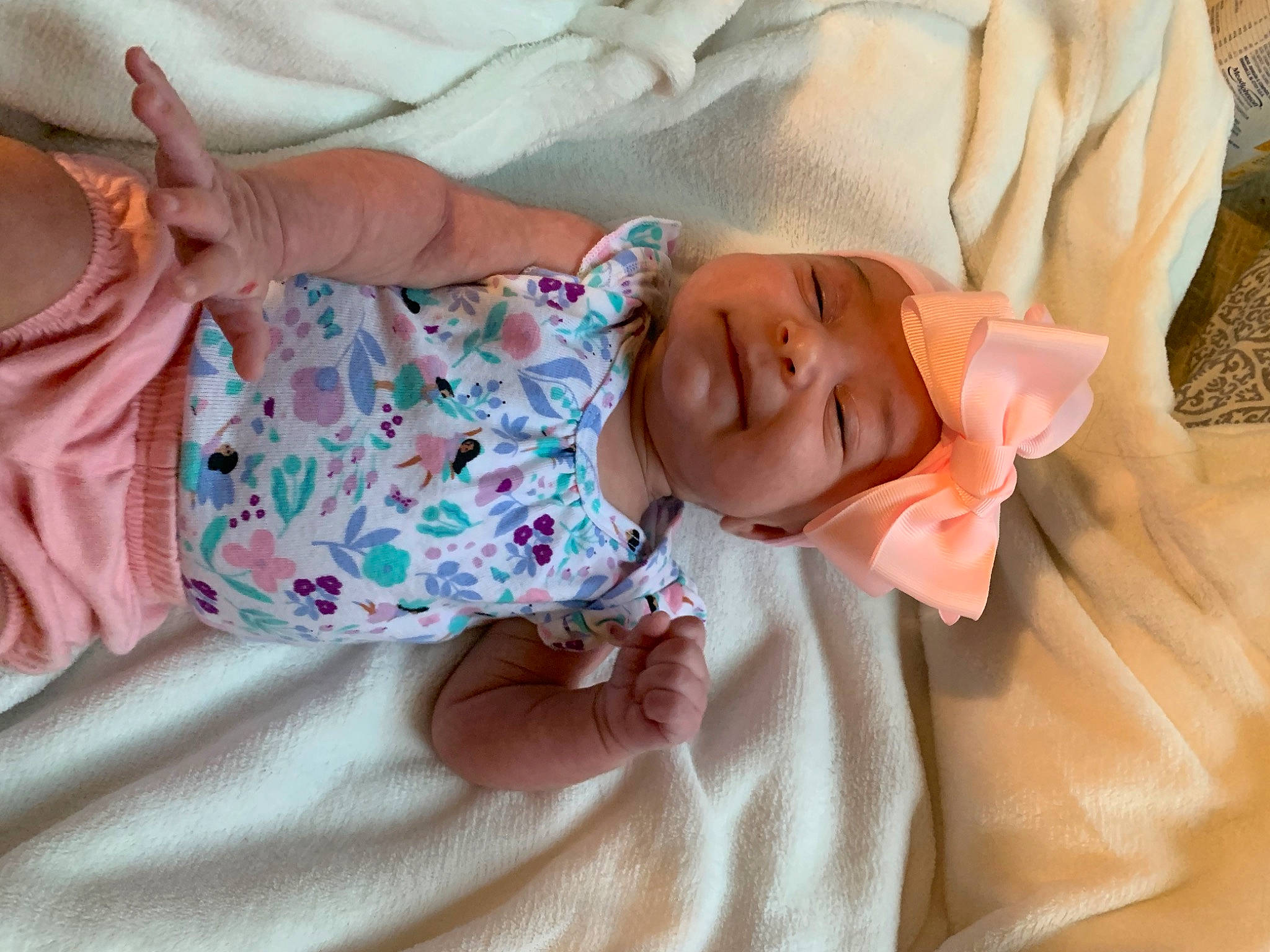 Kora is registered to the contest to win money with this photo: baby, baby_toddler_clothing, bedtime, child, comfort, eye, finger, hand, happy, hat, head, headwear, human_body, linens, pattern, person, pink, skin, sleeve, smile