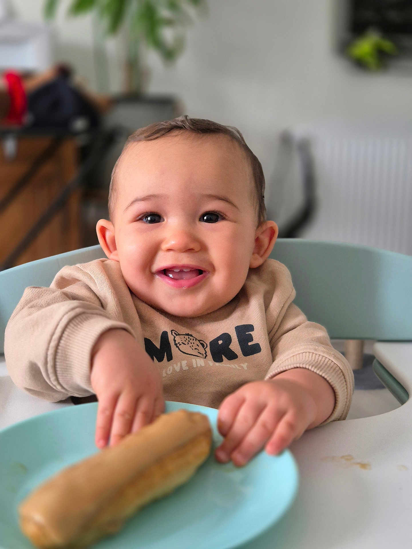 Tommy a rejoint le concours — aidez-le/la à gagner de superbes lots ! baby, child, smile, happy, high_chair, plate, pastry, food, indoor, table, clothing, face, hands, cute, person, sitting, meal, delicious, breakfast, kitchen