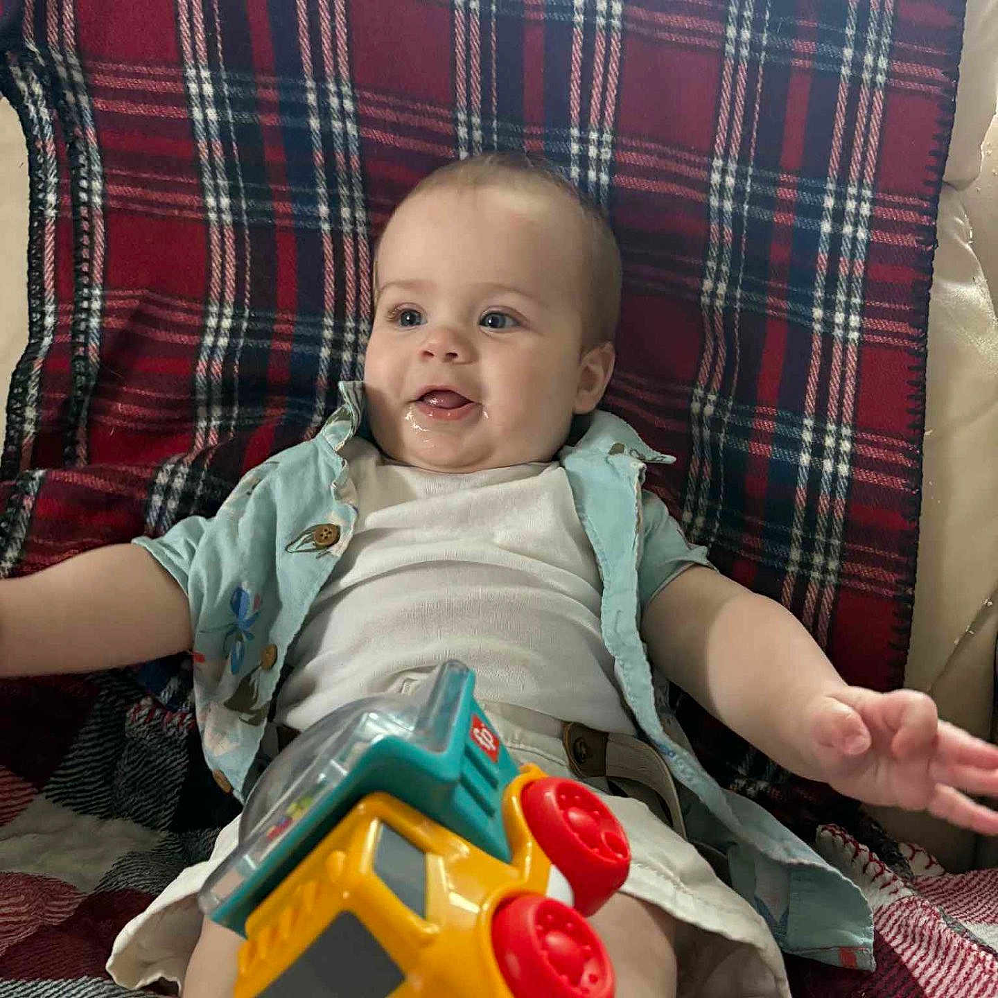 Lucas joined the competition — help win amazing prizes! baby, cheerful, child, clothing, colorful, cute, face, hand, happy, indoor, infant, legs, onesie, person, plaid_blanket, play, relax, shirt, smiling, toy_truck