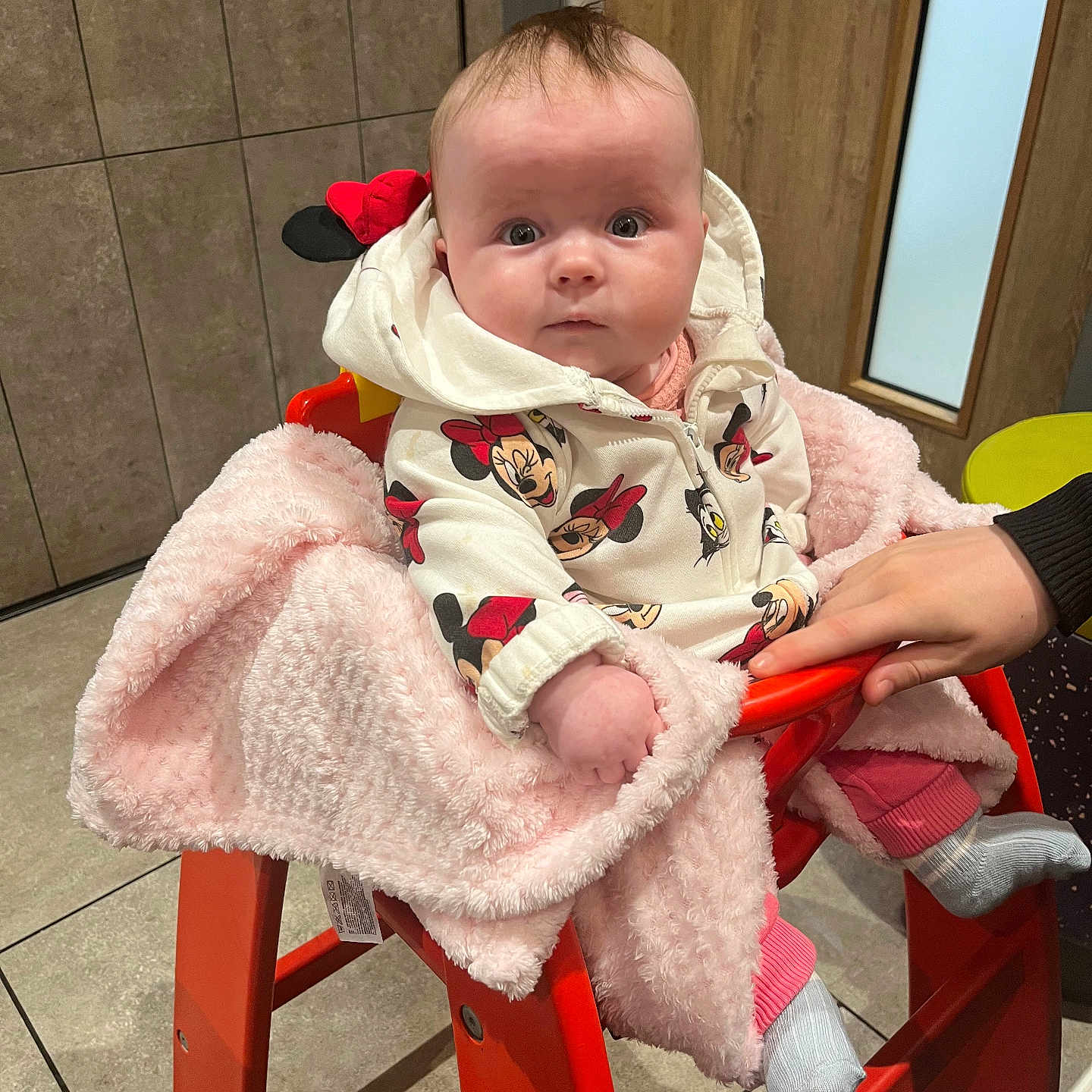 Ivory-Anne joined the competition — help win amazing prizes! baby, blanket, child, clothing, cute, door, floor, hand, high_chair, hoodie, indoor, infant, minnie_mouse, orange, person, pink, seated, tile, warm, wooden_door