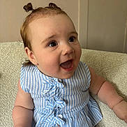 Harper is registered to the contest to win money with this photo: baby, child, smiling, happy, pigtails, blue_striped_clothing, sitting, indoors, face, cute, infant, person, cheerful, portrait, skin, arm, texture, fabric, young, expression