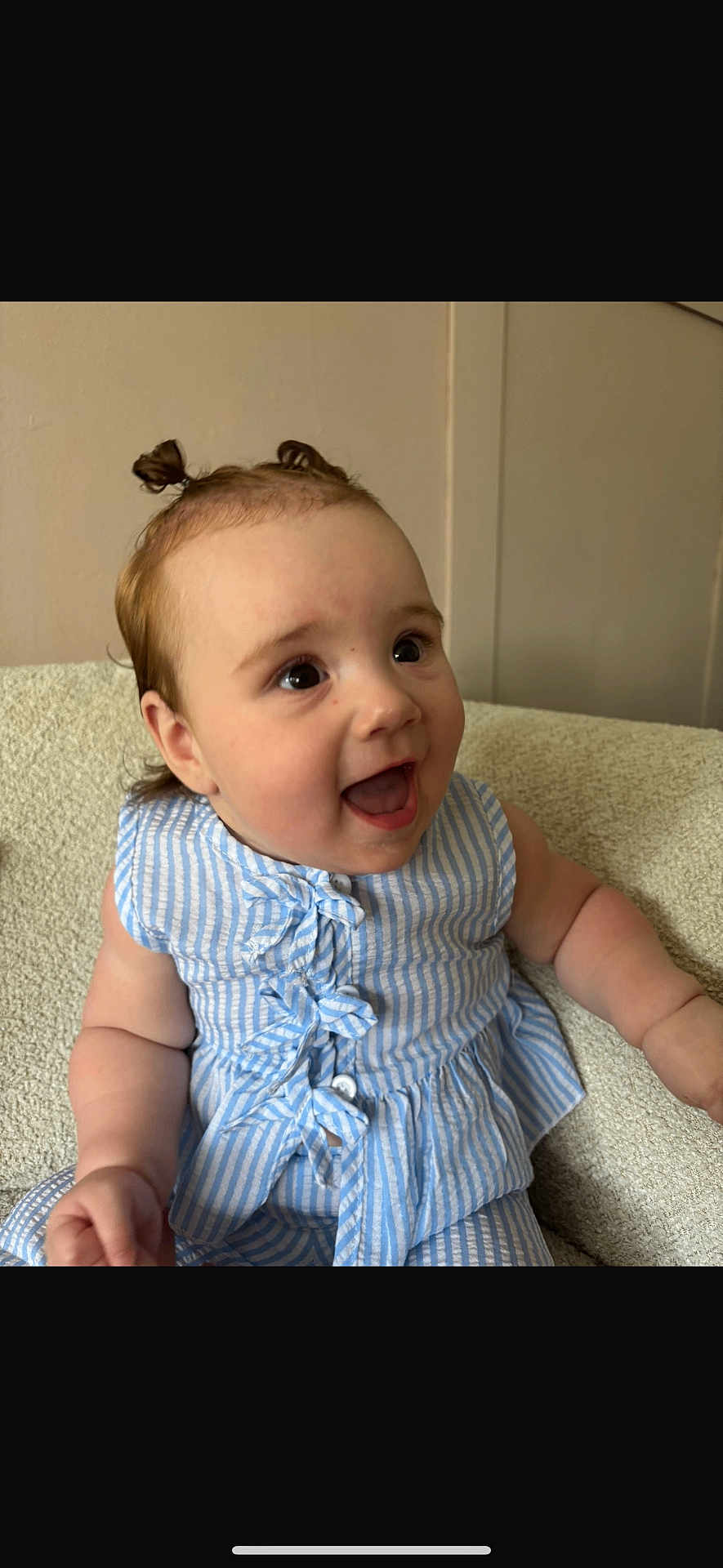 Harper is registered to the contest to win money with this photo: baby, child, smiling, happy, pigtails, blue_striped_clothing, sitting, indoors, face, cute, infant, person, cheerful, portrait, skin, arm, texture, fabric, young, expression