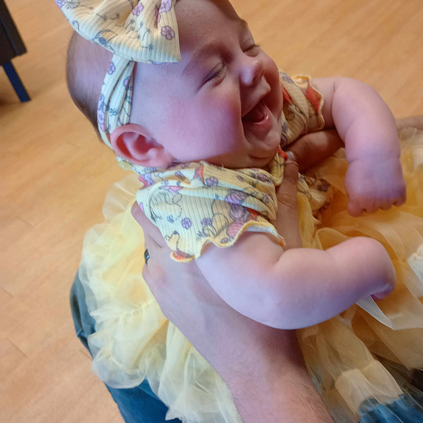 Kendrie is registered to the contest to win money with this photo: arm, baby, bow, child, clothing, cute, dress, floor, hand, happy, headband, holding, indoor, infant, joy, laughing, person, smiling, tattoo, tutu