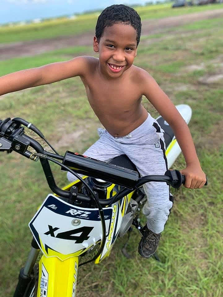 Alijah is registered to the contest to win money with this photo: adventure, barechested, bicycle_frame, bicycle_handlebar, carbon, competition_event, grass, grassland, happy, individual_sports, joy, leisure, motorcycle, people_in_nature, person, personal_protective_equipment, recreation, sky, smile, sports