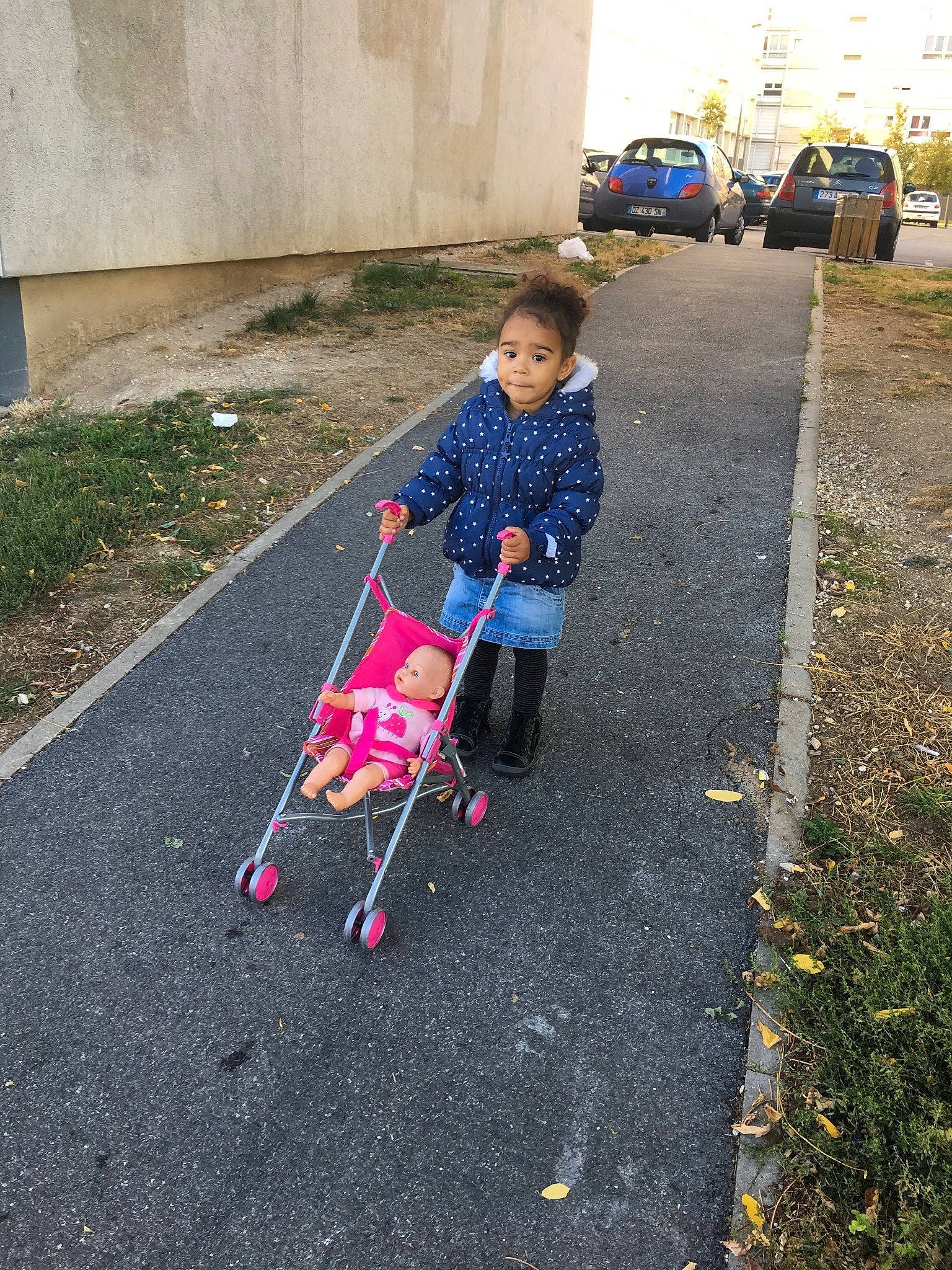 Naomy participe au concours pour gagner de l'argent avec cette photo : asphalt, baby_products, child, leaf, person, plant, play, product, road_surface, sidewalk, sitting, soil, tree, vehicle, walking