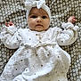 Emma a rejoint le concours — aidez-le/la à gagner de superbes lots ! baby, infant, headband, white_dress, patterned_blanket, lying_down, cute, chubby_cheeks, wide_eyes, hands_up, soft_fabric, closeup, portrait, indoor, child, adorable, newborn, small_hands, headwear, baby_fashion