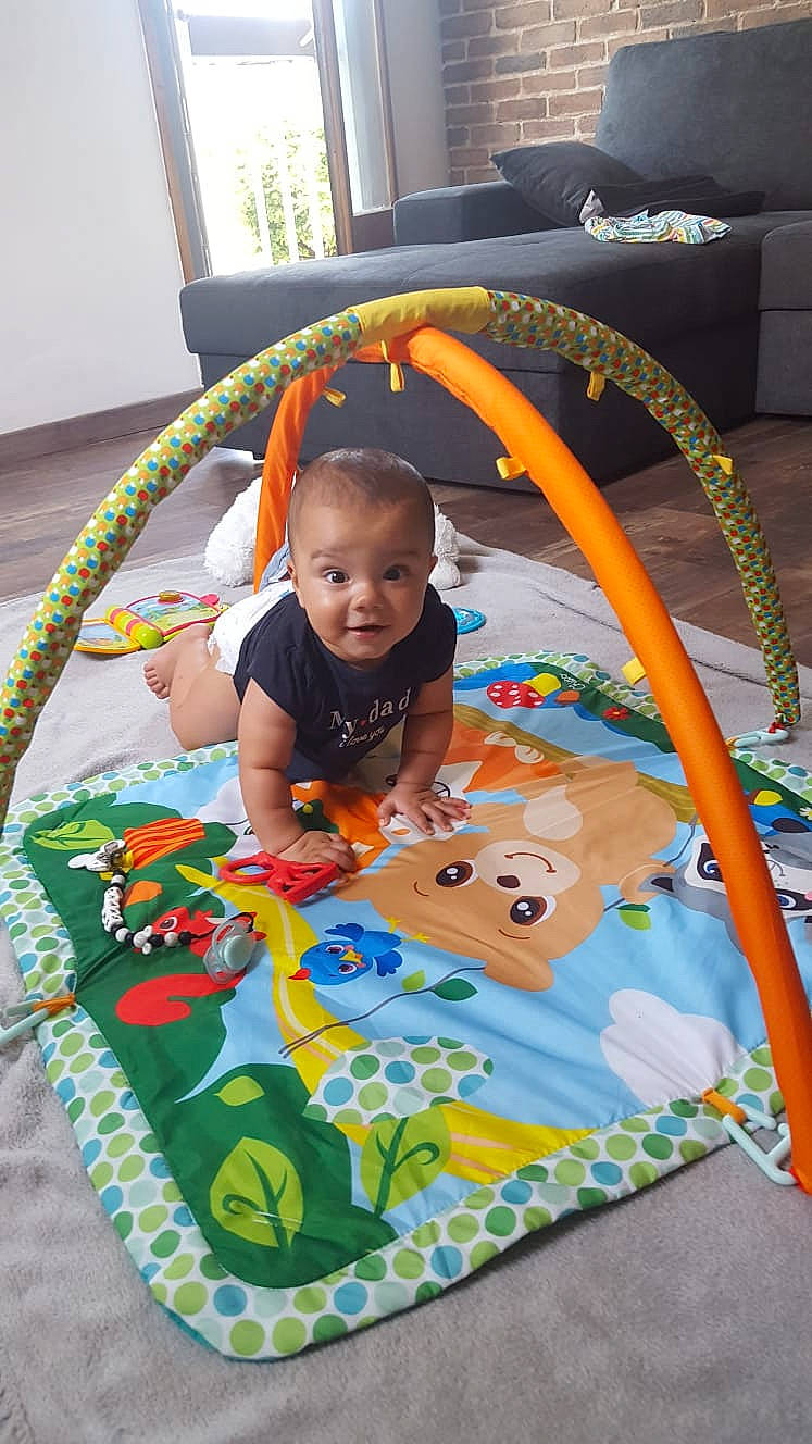 Chams participe au concours pour gagner de l'argent avec cette photo : baby, baby_products, baby_toddler_clothing, baby_toys, child, comfort, flooring, fun, grass, leisure, linens, pattern, person, play, playmat, recreation, room, smile, t_shirt, toddler
