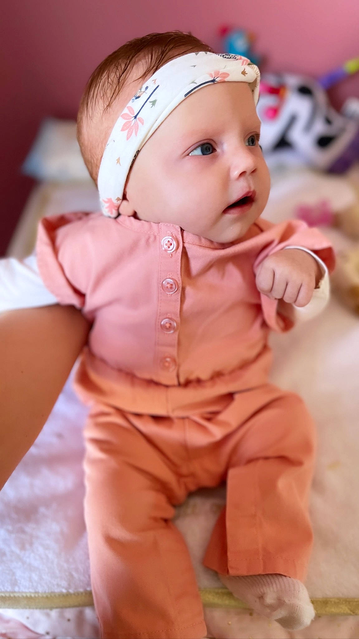 Romy participe au concours pour gagner de l'argent avec cette photo : baby, baby_toddler_clothing, cap, cheek, child, face, fashion_accessory, fun, happy, hat, head, headband, headwear, mammal, peach, person, pink, sitting, skin, sleeve