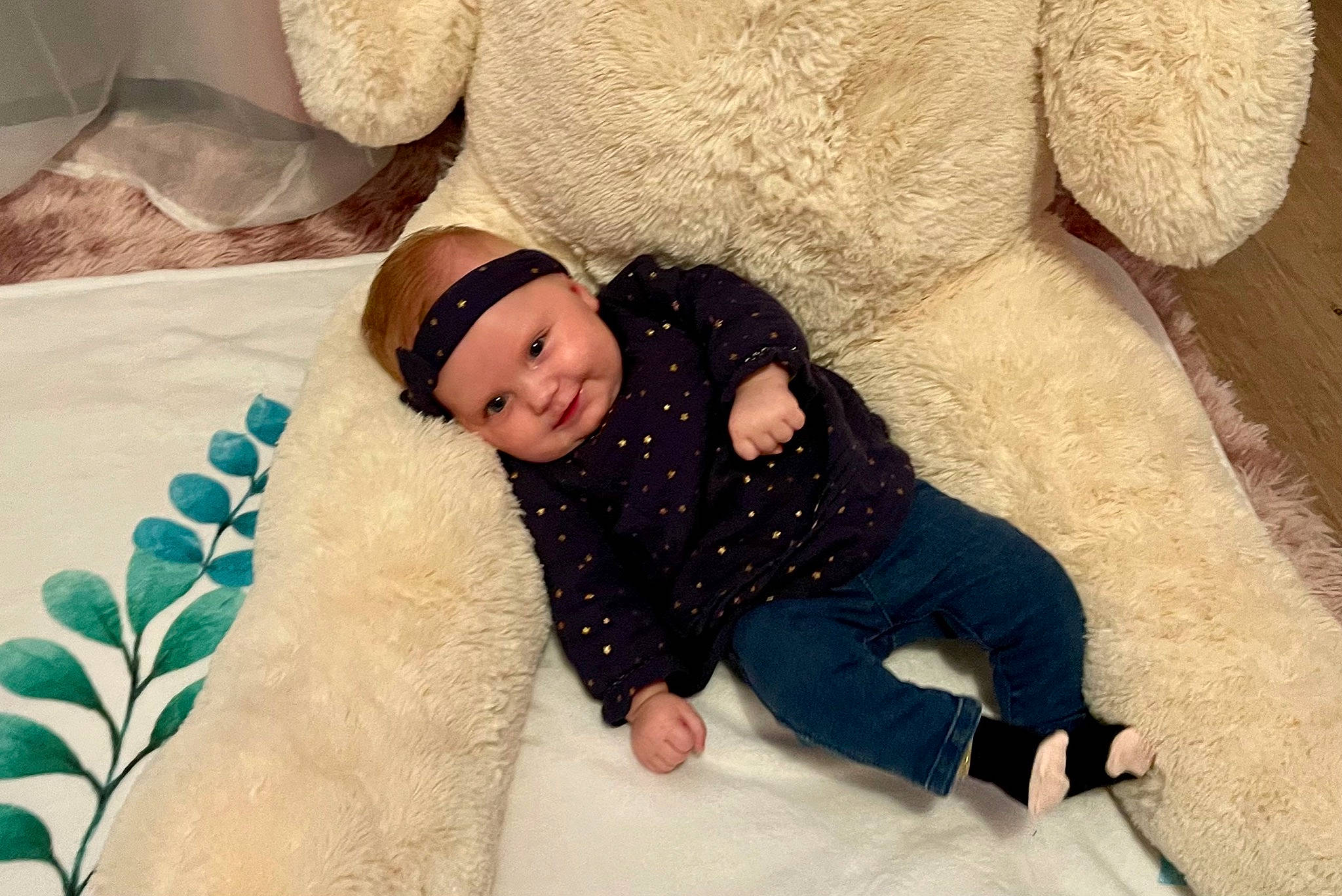 Romy participe au concours pour gagner de l'argent avec cette photo : baby, bedding, child, comfort, couch, eye, face, flooring, fur, happy, hat, headwear, human, joy, leisure, linens, person, room, sitting, teddy_bear