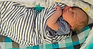 Tommie is registered to the contest to win money with this photo: baby, baby_wipes, blanket, checkered_blanket, child, cozy, cute, face, head, indoor, infant, newborn, pacifier, peaceful, portrait, resting, sleeping, soft, striped_clothing, swaddle