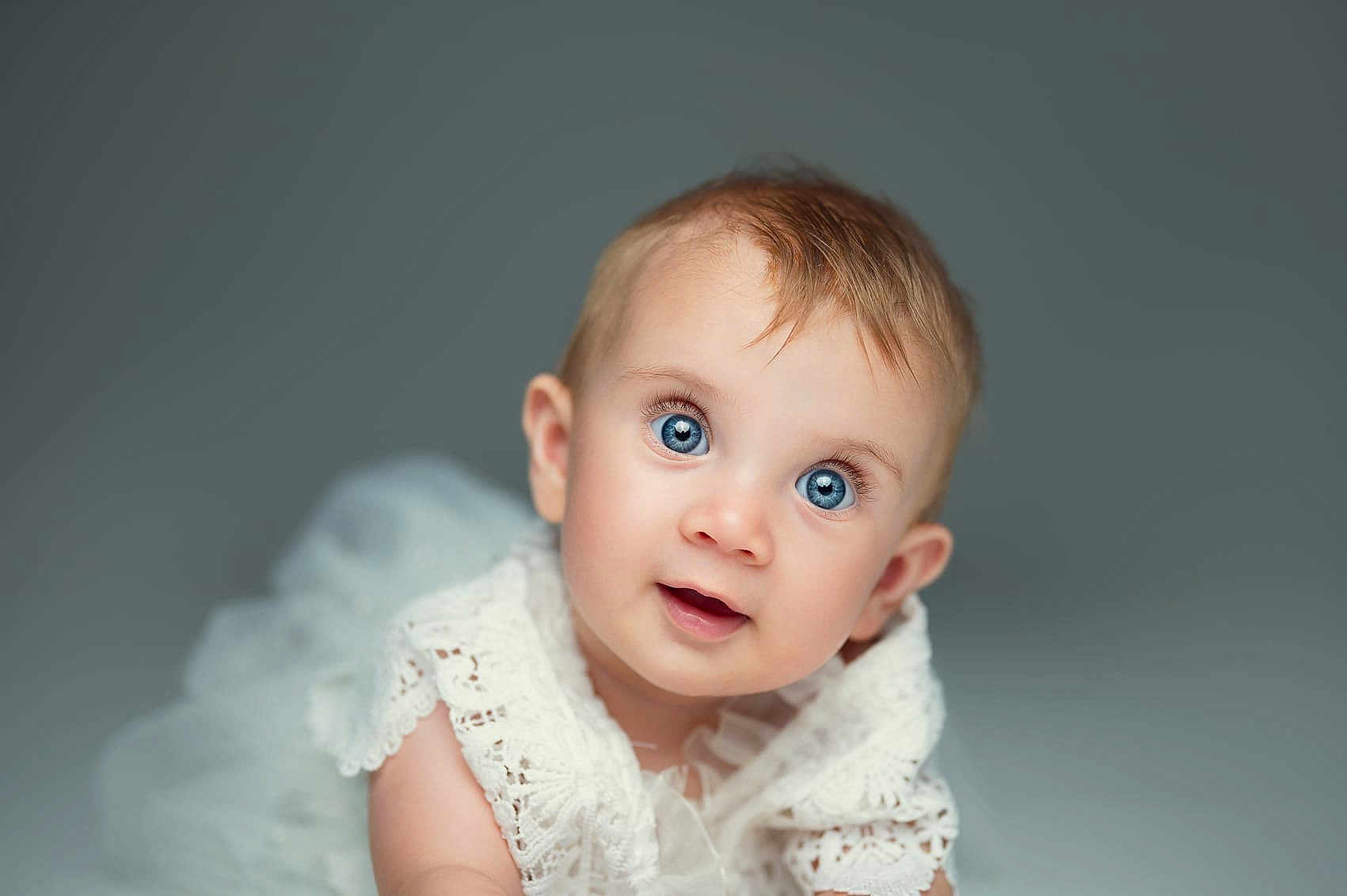 Adèle participe au concours pour gagner de l'argent avec cette photo : baby, blue_eyes, curious, face, lace, white_clothing, portrait, studio, soft_focus, infant, cute, child, closeup, head, smiling, young, person, background, expression, skin