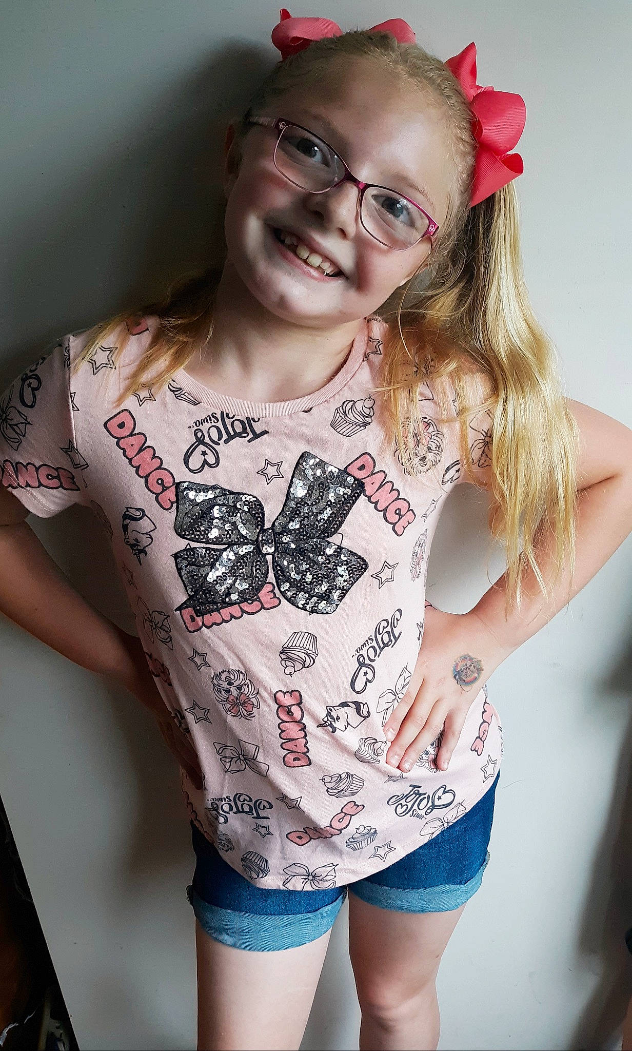 Jadyn is registered to the contest to win money with this photo: arm, blond, clothing, cool, eyewear, finger, gesture, glasses, hand, joy, leg, lip, long_hair, person, shorts, shoulder, sleeve, smile, t_shirt, top