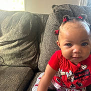 Aliza joined the competition — help win amazing prizes! toddler, child, baby, couch, sofa, red_clothing, minnie_mouse, hair_bows, polka_dots, socks, indoor, smiling, cute, playful, person, infant, seated, home, portrait, bright_eyes