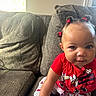 toddler, child, baby, couch, sofa, red_clothing, minnie_mouse, hair_bows, polka_dots, socks, indoor, smiling, cute, playful, person, infant, seated, home, portrait, bright_eyes