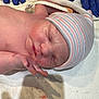 Irene is registered to the contest to win money with this photo: newborn, baby, sleeping, infant, hospital, hat, striped_hat, gloves, blue_gloves, towel, skin, face, hand, closeup, medical, fresh, cute, tiny, peaceful, newborn_baby
