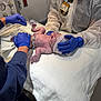 newborn, baby, hospital, medical_staff, gloves, blanket, umbilical_cord, medical_equipment, healthcare, person, face, hat, bed, white, blue_gloves, nurse, doctor, clinic, patient, care
