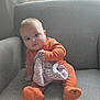 Toby is registered to the contest to win money with this photo: armchair, baby, blanket, child, cozy, curious, cute, expression, face, feet, hands, home, indoor, infant, natural_light, orange_pajamas, portrait, seated, soft_toys, window