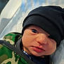 Toby is registered to the contest to win money with this photo: baby, infant, face, headwear, beanie, clothing, green, camouflage, hoodie, portrait, closeup, eyes, skin, mouth, nose, soft, blanket, indoor, young, cute