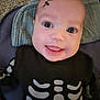baby, black_clothing, closeup, clothing, costume, cute, eyes, fabric, face, happy, head, indoors, infant, joyful, lightning_bolt, person, portrait, skeleton, smile, texture