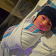 Toby joined the competition — help win amazing prizes! newborn, baby, hospital, blanket, swaddled, hat, bassinet, infant, bed, face, person, sleeping, cute, child, newborn_care, healthcare, portrait, resting, wrapped, hospital_room