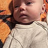 baby, infant, face, person, clothing, blanket, orange, pattern, laying, portrait, child, cute, skin, eyes, head, young, sleepwear, soft, indoors, expression