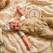 Juniper joined the competition — help win amazing prizes! baby, infant, smiling, tongue_out, headband, overalls, blanket, teddy_bear, greenery, laying_down, cute, child, three_months, indoors, cozy, happy, portrait, soft_light, fabric, decor