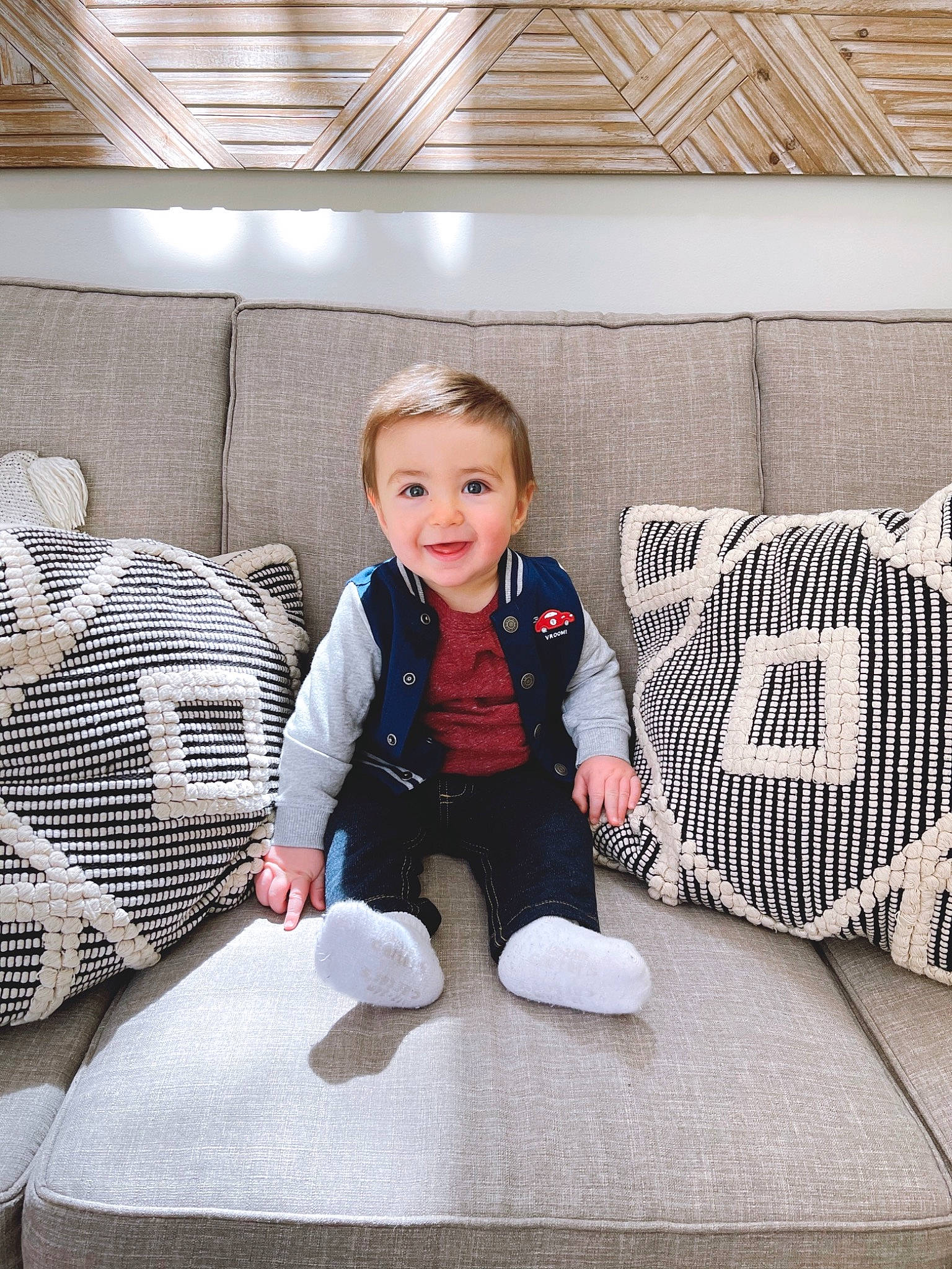 Samson is registered to the contest to win money with this photo: automotive_design, baby, baby_toddler_clothing, chair, comfort, couch, floor, flooring, formal_wear, interior_design, joy, knee, living_room, pattern, person, sitting, sleeve, smile, sneakers, suit