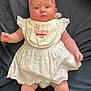 Delilah joined the competition — help win amazing prizes! baby, infant, child, white_dress, pink_headband, bow, bib, lying_down, blue_eyes, chubby_arms, chubby_legs, cute, portrait, indoors, fabric, cloth, skin, person, newborn, love