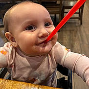 Aurora is registered to the contest to win money with this photo: baby, child, face, straw, messy, happy, smile, highchair, clothing, table, wood, indoor, restaurant, person, cute, expression, food, sitting, pink, infant