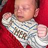Luca is registered to the contest to win money with this photo: baby, newborn, sleeping, pajamas, blanket, red_blanket, infant, child, cozy, hands, face, peaceful, cute, portrait, indoor, soft, resting, person, young, small