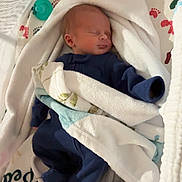 River is registered to the contest to win money with this photo: newborn, baby, sleeping, blanket, onesie, cozy, soft, infant, bed, comfort, toddler, pacifier, footprint_pattern, fabric, cushion, nursery, child, rest, peaceful, sleep