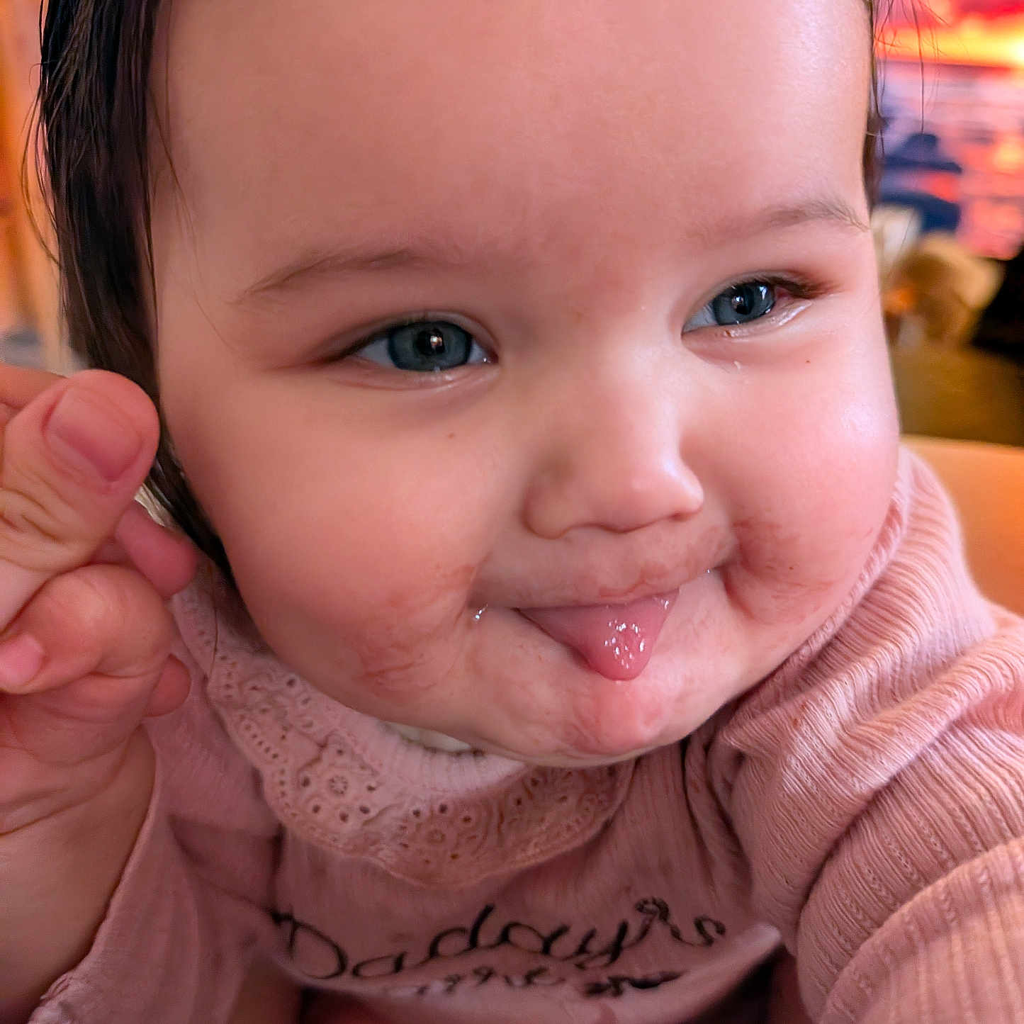 Aria joined the competition — help win amazing prizes! baby, infant, child, portrait, close_up, face, smiling, tongue_out, rosy_cheeks, blue_eyes, brown_hair, pink_clothing, bib, long_sleeves, hand, indoor, cozy, happy, adorable, photography