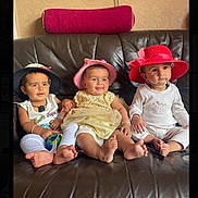 Alayna joined the competition — help win amazing prizes! baby, child, infant, hat, couch, leather, smiling, seated, indoors, cute, family, sitting, three_children, clothing, footwear, headwear, playful, happy, portrait, toddler