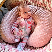 Charlee joined the competition — help win amazing prizes! baby, infant, pink, plush, cushion, blanket, knit, cozy, onesie, patterned_clothing, indoor, child, portrait, soft_texture, seated, cute, face, looking_away, resting, comfortable