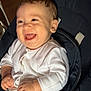 baby, smiling, happy, infant, white_clothing, baby_seat, seatbelt, child, cute, joyful, indoor, person, young_child, human, small_hands, sitting, face, cheerful, light_skin, short_hair