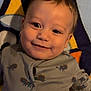 Anakin is registered to the contest to win money with this photo: apparel, baby, blanket, child, colorful, cute, face, happy, head, indoor, infant, lion_pattern, lying_down, onesie, person, portrait, skin, smiling, soft_texture, young_child