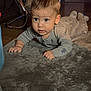 baby, carpet, child, clothing, crawling, curious, expression, face, fan, floor, head, home, indoor, infant, lighting, pajamas, person, soft, wood_floor, young