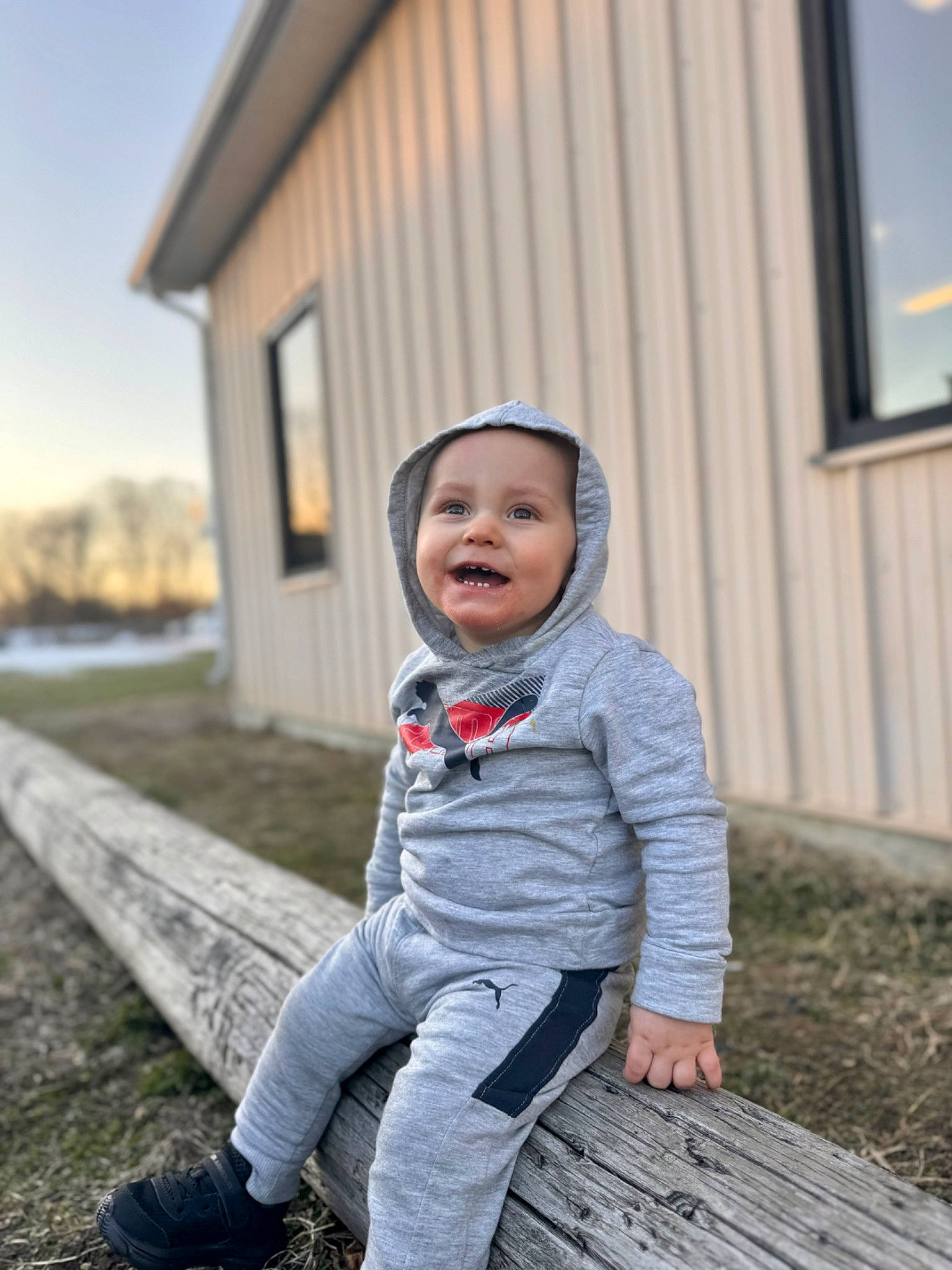 Sawyer is registered to the contest to win money with this photo: baby_toddler_clothing, building, eye, flash_photography, grass, happy, head, house, joy, leaf, people, people_in_nature, person, photograph, plant, sky, smile, standing, toddler, tree