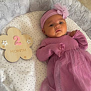 Isabelle Felice joined the competition — help win amazing prizes! baby, infant, pink_dress, headband, flower, wooden_plaque, milestone, two_months, blanket, stars, soft_texture, cushion, lying_down, indoors, child, cute, portrait, newborn, fabric, resting
