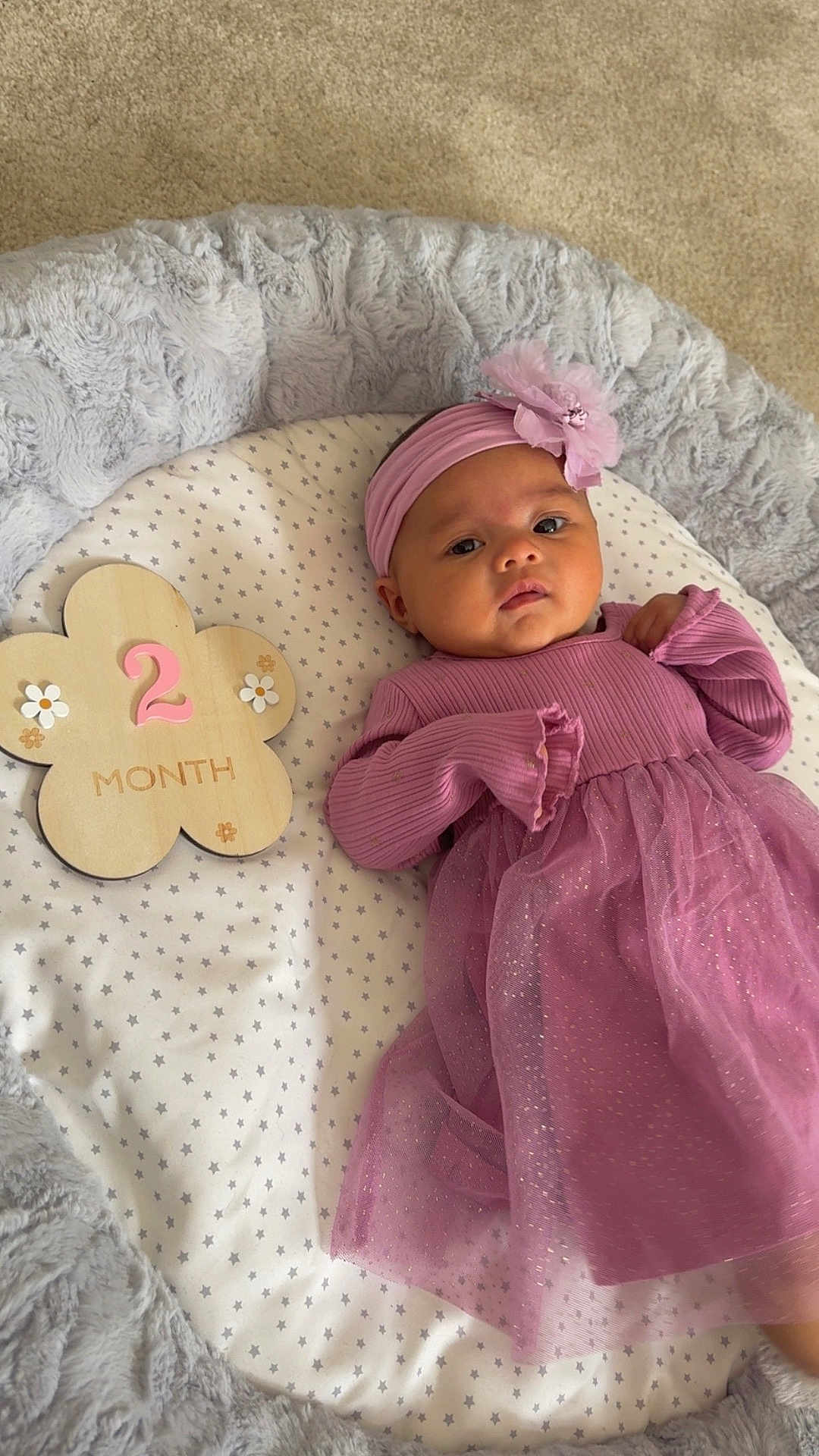 Isabelle Felice joined the competition — help win amazing prizes! baby, infant, pink_dress, headband, flower, wooden_plaque, milestone, two_months, blanket, stars, soft_texture, cushion, lying_down, indoors, child, cute, portrait, newborn, fabric, resting