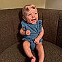 baby, infant, smiling, denim, romper, headband, bow, couch, brown, texture, happy, sitting, barefoot, cute, indoors, child, portrait, skin, person, furniture