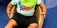 Ryland is registered to the contest to win money with this photo: toddler, child, baby, slide, playground, curly_hair, bib, shirt, shorts, barefoot, carpet, indoor, smiling, person, play, fun, hand, foot, head, peeking_child