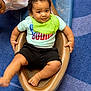 toddler, child, baby, slide, playground, curly_hair, bib, shirt, shorts, barefoot, carpet, indoor, smiling, person, play, fun, hand, foot, head, peeking_child