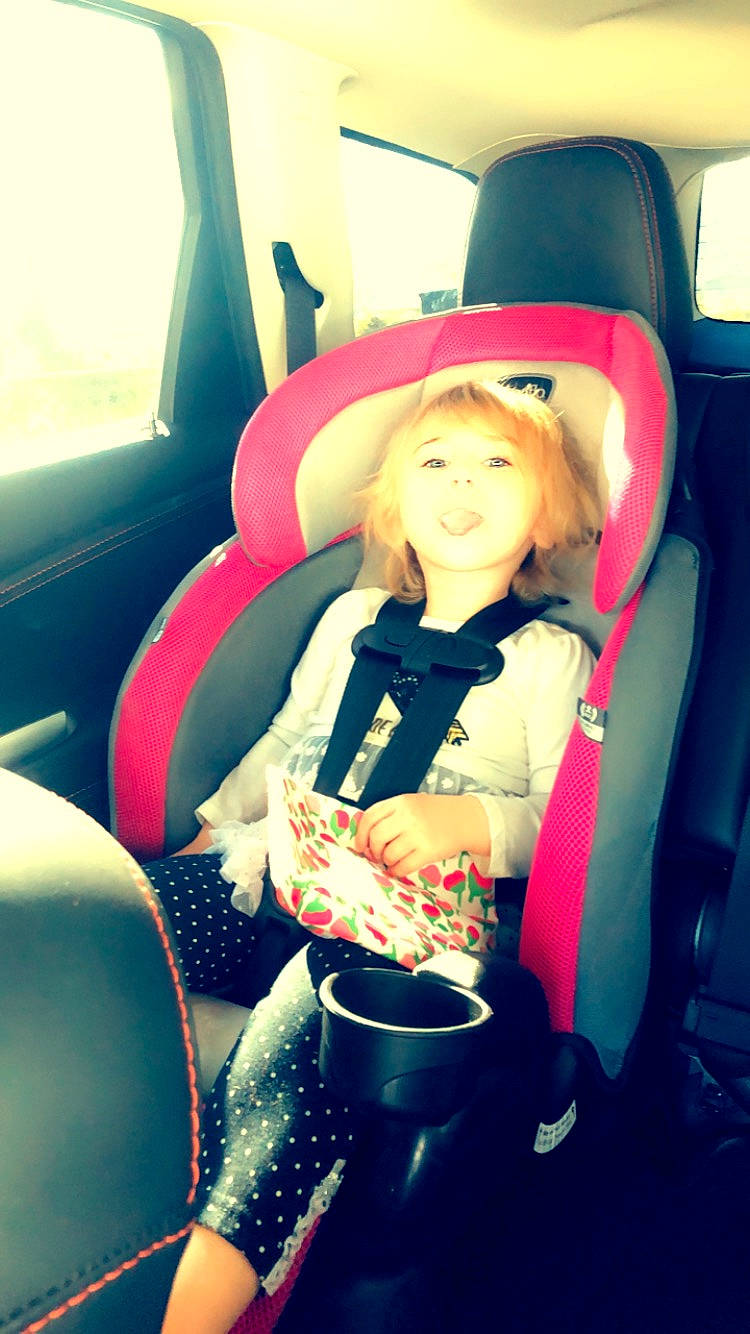 Aubri joined the competition — help win amazing prizes! auto_part, baby_in_car_seat, car, car_seat, car_seat_cover, child, family_car, hat, head_restraint, person, pink, seat_belt, sitting, steering_wheel, toddler, vehicle