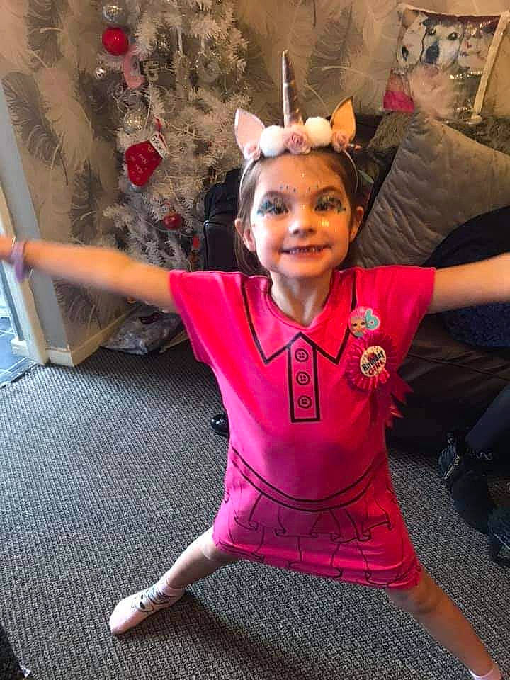 Gracie joined the competition — help win amazing prizes! chair, child, costume, event, fashion_accessory, flooring, fun, happy, holiday, joy, magenta, person, pink, purple, room, selfie, sitting, sleeve, smile, sportswear